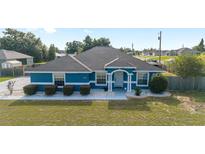 Overhead shot of a charming blue single-story home with a well-kept lawn and landscaped front yard at 13115 Sw 49Th Ave, Ocala, FL 34473
