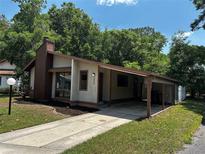 Charming single-Gathering home featuring a cozy carport and a lush green front yard at 1809 Sw 29Th Ter, Ocala, FL 34474