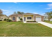 Charming yellow home with brick accents, attached garage, and well-maintained lawn at 2158 Nw 50Th Ave, Ocala, FL 34482