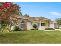 Charming yellow home with well-manicured lawn and lush landscaping creates great curb appeal at 2158 Nw 50Th Ave, Ocala, FL 34482