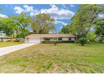 Charming single-story home with a well-manicured lawn and mature trees at 2220 Ne 41St St, Ocala, FL 34479
