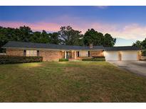 Charming brick ranch home with a well-maintained front yard and mature trees at 3950 Se 10Th Ln, Ocala, FL 34471