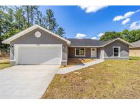 Charming single-story home featuring a neutral exterior and a two-car garage at 6689 Nw 61St St, Ocala, FL 34482