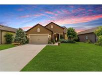 Charming single-story home with a well-manicured lawn, beautiful landscaping, and a two-car garage at 6868 Sw 95Th Cir, Ocala, FL 34481