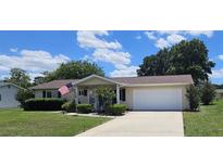 Charming home with a well-manicured lawn, attached two-car garage, and inviting covered porch at 8244 Sw 106Th Pl, Ocala, FL 34481