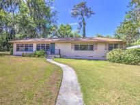 Charming single-story home with a well-manicured lawn, mature trees, and a walkway leading to the entrance at 834 Ne 10Th Ave, Ocala, FL 34470
