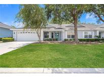 Charming single-story home features a well-manicured lawn, two-car garage, and a lovely light-blue front door at 9287 Sw 91St Court Rd, Ocala, FL 34481