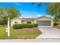Charming single-story home featuring a well-manicured lawn and an attached two-car garage at 11245 Sw 63Rd Terrace Rd, Ocala, FL 34476