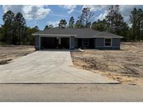 New construction single-story home featuring an attached two-car garage and a concrete driveway at 15419 Sw 65Th Terrace Rd, Ocala, FL 34473