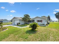 Charming home with a well-manicured lawn, attached garage, and welcoming entrance on a sunny day at 17915 Se 102Nd Ter, Summerfield, FL 34491