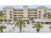 Condo building exterior with lush palm trees and convenient parking spaces at 420 Bouchelle Dr # 204, New Smyrna Beach, FL 32169