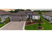 Beautiful home featuring a stone facade, a well-manicured lawn, and a two-car garage at 8606 Sw 61St Loop, Ocala, FL 34481