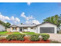 Charming single-story home with white siding, shutters, manicured lawn, and brick driveway at 8622 Baylor Cir, Orlando, FL 32817