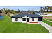Charming single-story home with a well-manicured lawn, black garage, and a welcoming front entrance at 904 Nw 67Th St, Ocala, FL 34474