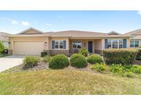 Inviting single Gathering home with manicured lawn, neutral paint and charming front porch at 9839 Sw 90Th St, Ocala, FL 34481
