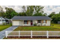 Charming single-story home featuring a well-kept lawn and a classic white picket fence at 2140 Ne 40Th St, Ocala, FL 34479