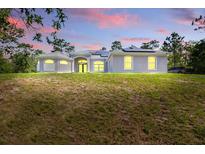 Charming single-story home featuring well-manicured lawn, arched windows, and a welcoming entrance at 22189 Sw Neptune Blvd, Dunnellon, FL 34431