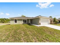 Charming single-story home featuring a well-manicured lawn and attached two-car garage at 25 Juniper Pass Way, Ocala, FL 34480