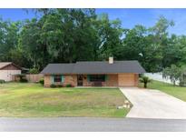 Charming single-story brick home featuring a well-manicured lawn and a classic brick facade at 2576 Ne 34Th St, Ocala, FL 34479