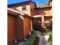 Inviting view of the home's exterior featuring warm wood tones, a quaint entryway and lush landscaping at 2701 Ne 10Th St # 403, Ocala, FL 34470