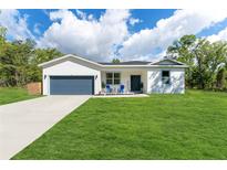 Charming single-story home featuring a well-manicured lawn and a two-car garage at 46 Fisher Lane Ter, Ocklawaha, FL 32179