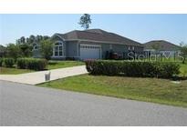 Charming single-story home featuring a well-maintained lawn and a long private driveway leading to an attached garage at 4770 Sw 114Th St, Ocala, FL 34476