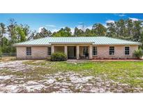 Charming single-story home featuring a light-colored metal roof and a simple, landscaped front yard at 505 Fisher Rd, Ocklawaha, FL 32179
