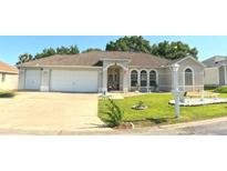 Charming single-story home featuring a well-manicured lawn and a spacious two-car garage at 5340 Nw 26Th Ln, Ocala, FL 34482