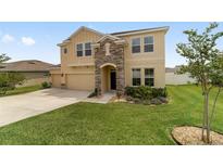 Charming two-story home featuring a stone-accented entrance and well-manicured front yard at 5653 Sw 50Th Ter, Ocala, FL 34474