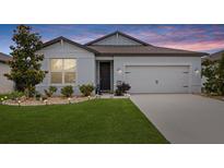 Charming single-story home featuring manicured lawn, landscaping, and attached two-car garage at 9459 Sw 52Nd Loop, Ocala, FL 34481