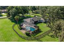 Aerial view of the property with a screened pool, fenced yard, and mature landscaping at 9462 Sw 72Nd Ct, Ocala, FL 34476