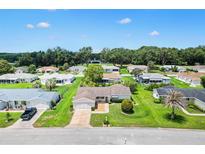 An aerial view of a single-Gathering home showcasing its manicured lawn and serene neighborhood setting at 9853 Se 175Th Pl, Summerfield, FL 34491