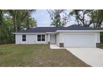 Charming single-story home with a well-manicured lawn and attached two-car garage at 17685 Sw 112Th Ln, Dunnellon, FL 34432