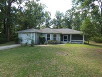 Charming single-story home with a well-maintained lawn and cozy screened front porch at 19026 Sw 100Th Pl, Dunnellon, FL 34432