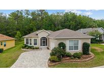 Quaint single Gathering home boasts a brick driveway, attached garage, and beautiful landscaping at 2631 Sw 20Th Cir, Ocala, FL 34471