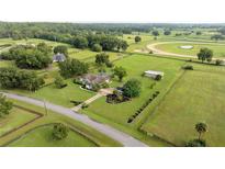 An aerial view of a sprawling property with a well-maintained home, lush greenery, and equestrian amenities at 5661 Nw 96Th Ln, Ocala, FL 34482