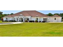 Spacious single-story home boasts a manicured lawn and classic white exterior at 6160 W Highway 326, Ocala, FL 34482