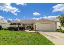 Charming single-story home with well-maintained landscaping and a two-car garage at 8352 Se 168Th Trinity Pl, The Villages, FL 32162