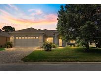 Charming home featuring a two-car garage and a well-manicured lawn at sunset at 9628 Sw 90Th St, Ocala, FL 34481