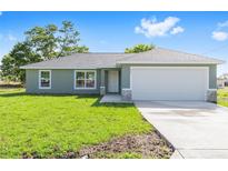 Charming single-story home with a well-maintained lawn and attached two car garage at 10124 Sw 130Th Ct, Dunnellon, FL 34432