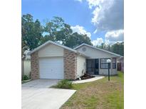 Charming single-story home with a brick-accented garage and well-manicured lawn at 2209 Ne 40Th Ave, Ocala, FL 34470