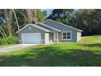 Charming single-story home featuring an attached two-car garage and a well-maintained front yard at 4121 Se 138Th Pl, Summerfield, FL 34491