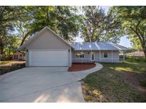 Charming single-story home featuring a two-car garage and a welcoming front porch at 9 Juniper Pass Trl, Ocala, FL 34480
