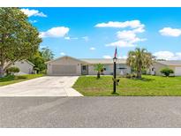 Charming single-story home with well-manicured lawn, palm trees, and an American flag in a serene neighborhood at 11237 Sw 78Th Ct, Ocala, FL 34476