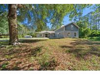 Charming two-story home with neutral paint, lush yard, and mature trees at 11521 Se 1St Street Rd, Silver Springs, FL 34488
