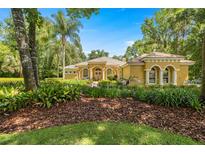 Well-manicured traditional-style home with meticulously landscaped front yard, flowerbeds, and tree-lined street at 1675 Se 73Rd Pl, Ocala, FL 34480