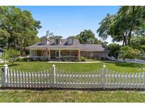 Charming brick home with a white picket fence and a cozy front porch, surrounded by lush greenery at 2820 Se 14Th St, Ocala, FL 34471