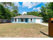 Charming blue single-story home with a well-manicured lawn and a one-car garage at 5193 Nw 61St Ave, Ocala, FL 34482
