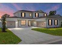 Elegant two-story home featuring a well-manicured lawn, a three-car garage, and classic architectural details at 7624 Sw 60Th St, Ocala, FL 34474