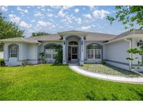 Charming single-story home featuring a well-manicured lawn and inviting front entry with arched window details at 11140 Sw 53Rd Cir, Ocala, FL 34476